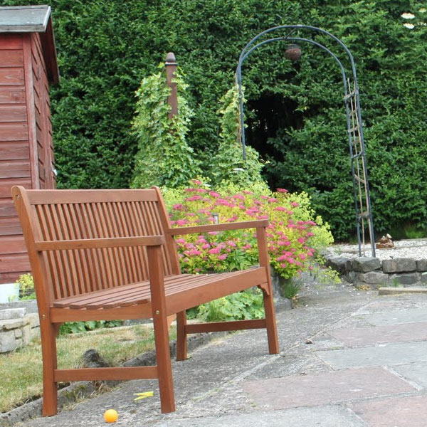 Wooden garden chari with hedge in background