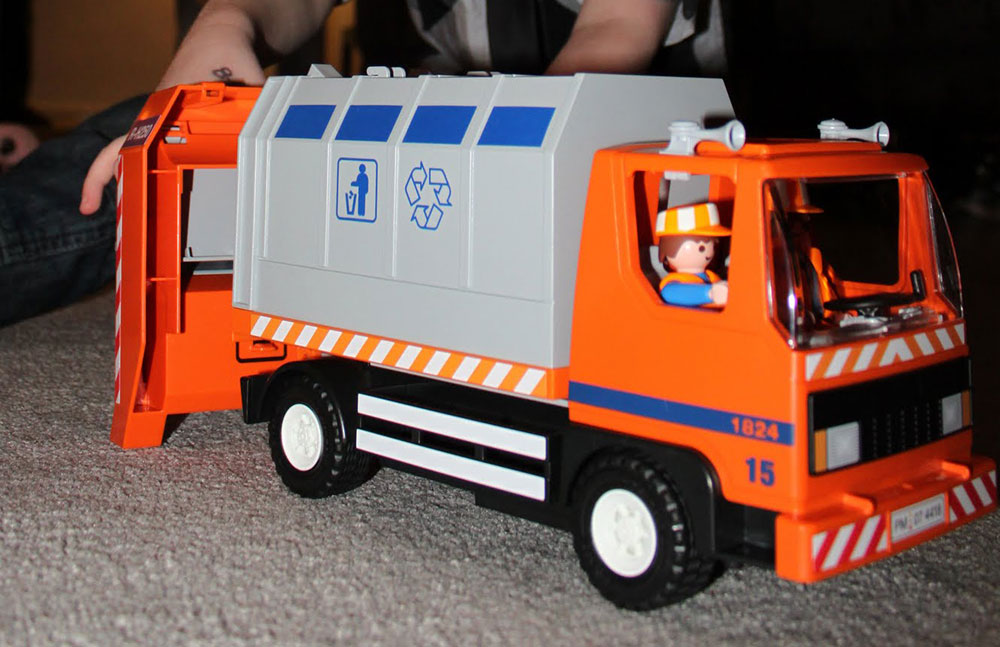 A plastic Playmobil bin lorry in grey and orange.